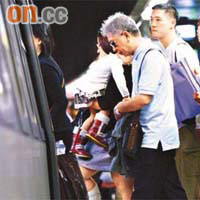 旺角東站<br>有手抱小孩的乘客小心翼翼踏過月台空隙，避免「差錯腳」。	（吳啟偉攝）