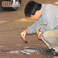 警方在現場路面檢視疑是死者遺下的破玻璃樽。
