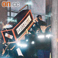 示威人士把紙製棺材抬至中聯辦後門外。