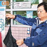 李先生展示其妻被電單車黨扯斷的黑色手袋。