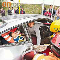 跑車司機受傷被困車內，一名醫療輔助隊隊員助救。	（林少兒攝）