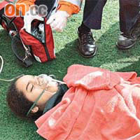 女生呼吸困難，需戴上氧氣罩急救。	（馬竟峰攝）