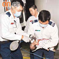 服藥後嘔吐昏迷的女嬰由救護員急救。	（楊日權攝）
