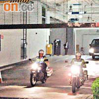 探員凌晨離開位於數碼港宏霸數碼時由警察電單車開路。	（曾昭安攝）