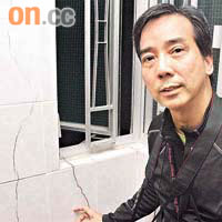 專業教育學院建築工程系主任陳子明發現單位牆身有明顯新裂痕。	（劉雲彪攝）