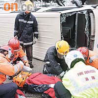 客貨車在迴旋處翻側，受傷乘客在現場接受急救。	（蘇仲賢攝）