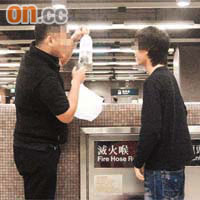 一名青年（右）在港鐵站內將來歷不明的「鈕扣」珊瑚交予買家。