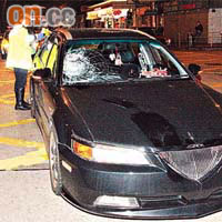 私家車擋風玻璃爆裂，警員在場調查。	（梁永雄攝）