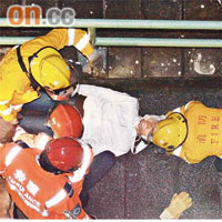 頌民樓攀欄跳樓重傷的男子，由消防員急救。（蕭偉健攝）