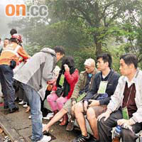 受傷深圳遊客坐在路邊等候送院。