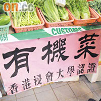 案中供應偽冒有機蔬菜的菜檔，檔主在檔前展示一幅寫有「有機菜，香港浸會大學認證」字樣的橫額誤導消費者。