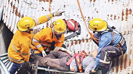 跳樓男子跌在鋅鐵平台頂，由消防員救下送院。	（陳錦昌攝）