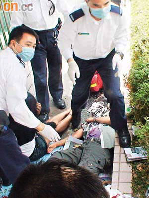 兩名受傷印傭倒臥地上，救護員為她們治理。	（吳欽旺攝）