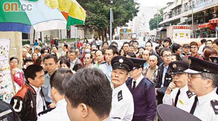 蔡婆婆的兒子（左一）被販管隊和警員包圍，大批市民圍觀，指摘食環署欺壓小販。	（黃美瑜攝）