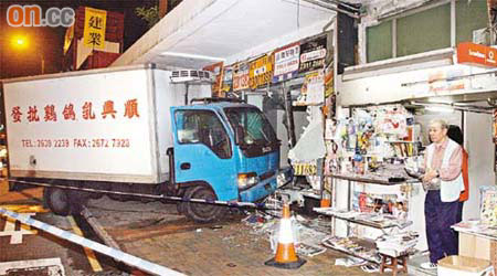 凍櫃貨車撞毀空舖，險死老報販在店旁講述經過。	（周宏杰攝）