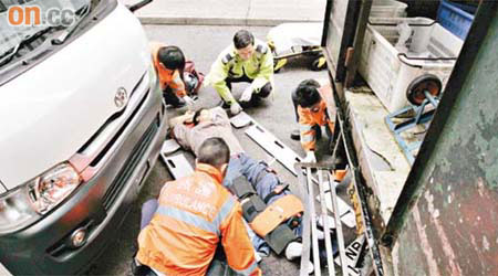 運魚車司機倒在地上，由救援人員急救。	（林少兒攝）