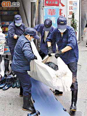 倒斃時鐘酒店房裏的男子由仵工舁送殮房。	（文健雄攝）