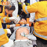 跳橋重傷青年倒臥路面，消防及救護員為他急救。