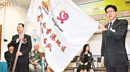 霍啟剛（右）獲廣州亞組委志願者部部長王煥清（前左）授旗，做廣州亞運會香港賽會志願者隊伍團長。	（楊歡成攝）