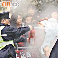 示威者焚燒貼有唐英年頭像及寫有「不要翻叮方案」的示威標語，被立會保安以滅火筒撲熄。
