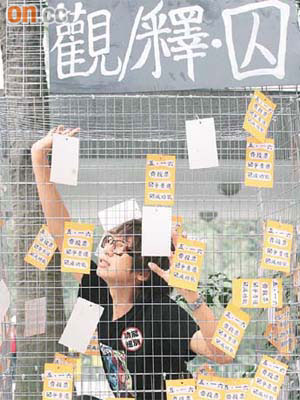 有大專生將自己囚在一個大鐵籠內，諷刺中央打壓「公投」及香港政制發展。	（伍鎮業攝）