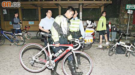 失事衝落山坡的單車由警員檢走。	（劉子文攝）