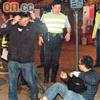 涉嫌醉酒駕駛的鐵騎士（坐地者）與乘客（左一）離開現場後被警方截獲。