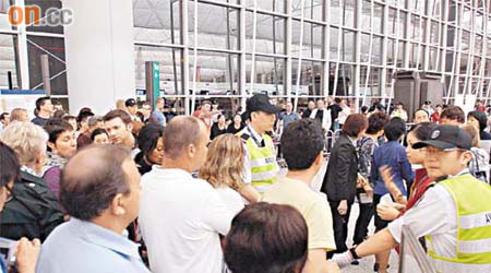 機場保安在國泰機場櫃位附近架起鐵欄分流人潮，防止混亂。	（張學儀攝）