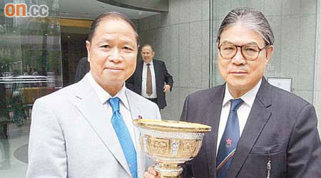 老撾奧委會主席Seng-Akhom（左）向霍震霆（右）送贈紀念金盃，代表老撾奧委會及市民一番心意。	（徐家浩攝）