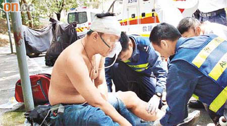 頭部受傷男子由救護員檢查傷勢。	（翁火攝）