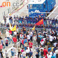 示威工人持竹竿及硬物與防暴警察對峙。
