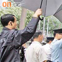 現場警員及曾蔭權的保鏢，高舉兩把大傘擋開豆腐及白紙。
