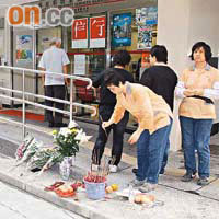 街坊及清潔工到葵盛東屋邨辦事處外置放鮮花及致祭。	（許錦雄攝）