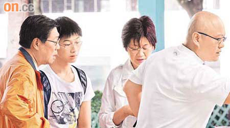 馬時亨（左一）與太太王培琪（右二）、妹夫（右一）及外甥探訪正生書院後，在港外線碼頭鄰近報攤買雜誌。	（陳嘉順攝）