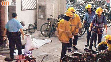 黃壹龍（左）與楊瀅（右）的屍體倒臥在行人路上，消防員在場處理。	（曾昭安攝）