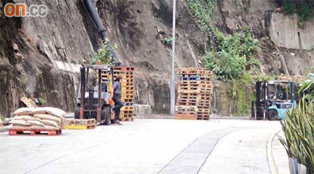 工人使用鏟車搬運貨物，更將貨物及卡板隨意堆放在馬路上。
