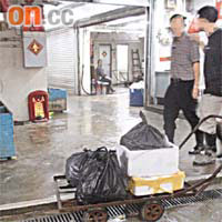 在流浮山鮮魚批發市場內，一架放有發泡膠箱及黑色膠袋的手推車停泊在茶餐廳附近。