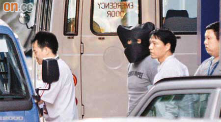 探員將一名被捕劫匪押往紅磡警署羈留。	（文健雄攝）