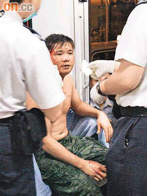 被指唱歌難聽的青年被毆傷，由救護員急救。	（楊日權攝）