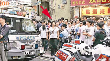 女子（箭嘴示）與警員理論時，圍觀市民起哄，指食環署職員詐傷。	（郭垂垂攝）