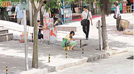 深圳街頭一名婦人，將香港六合彩報收藏在背包內向途人兜售。