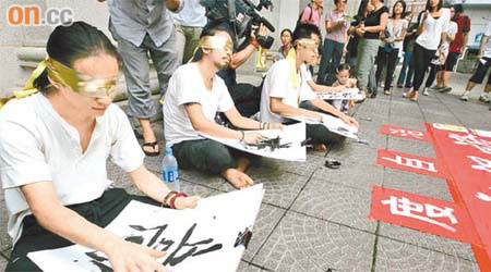 示威人士在大樓外連續廿二小時「蒙眼」書寫，要求港府撤回政改方案。	（陳德賢攝）