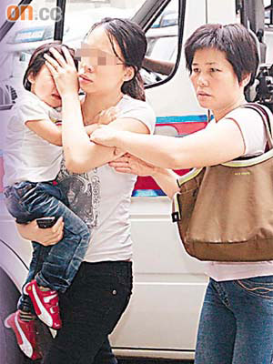 猝死女嬰母親抱着長女趕往醫院。	（林明強攝）