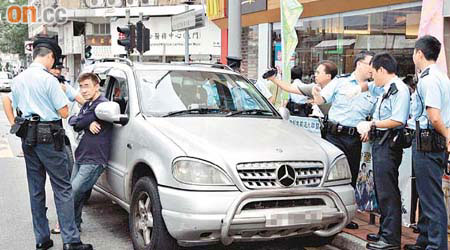 司機（左二）昏睡車內，多名警員到場調查。	（冼耀華攝）