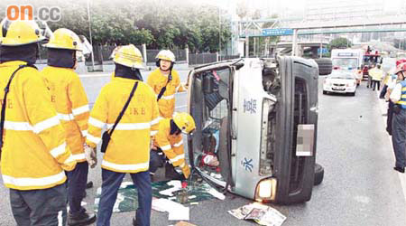 客貨車翻側路中，司機不知所終。	（周宏杰攝）