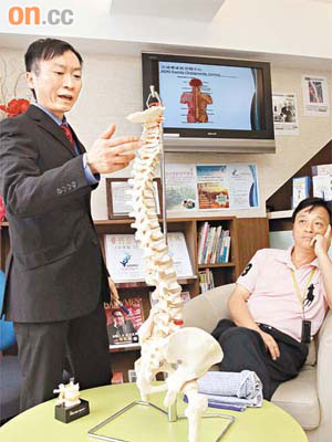黃先志（左）指，黃先生（右）的脊椎錯位，令頸背出現痛症。	（陳德賢攝）