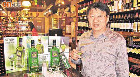 余壽寧喺店舖示範飲用Absenta，笑謂自創飲法可提高品酒嘅趣味性。     （余素月攝）