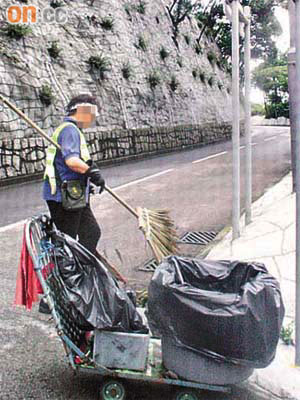 短髮戴眼鏡女工<br>日期：六月十七日<br>08:30 a.m. 身穿食環署制服的女清潔工在灣仔峽公園一帶打掃