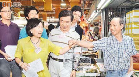 梁美芬（前左一）喺北河街街市派《滅鼠天書》。	（徐家浩攝）