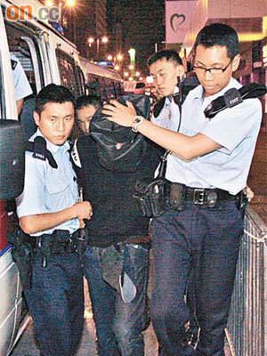 涉嫌冒警搶劫的男子，被警員拘捕押走。	（吳建明攝）